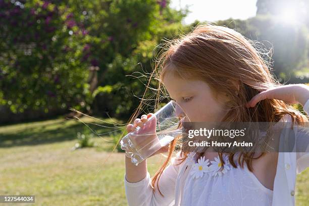 girl drinking glass of water in backyard - drinking water outside stock pictures, royalty-free photos & images