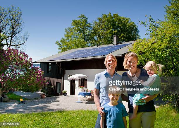 family at home with solar panel - bavarian man in front of house stock-fotos und bilder