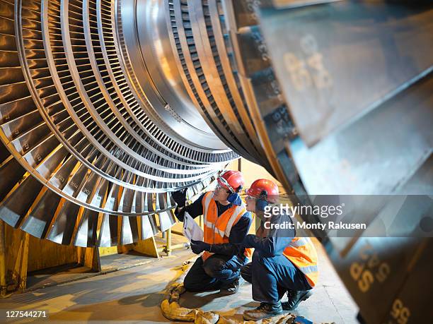 workers inspect turbine in power station - industrie photos et images de collection