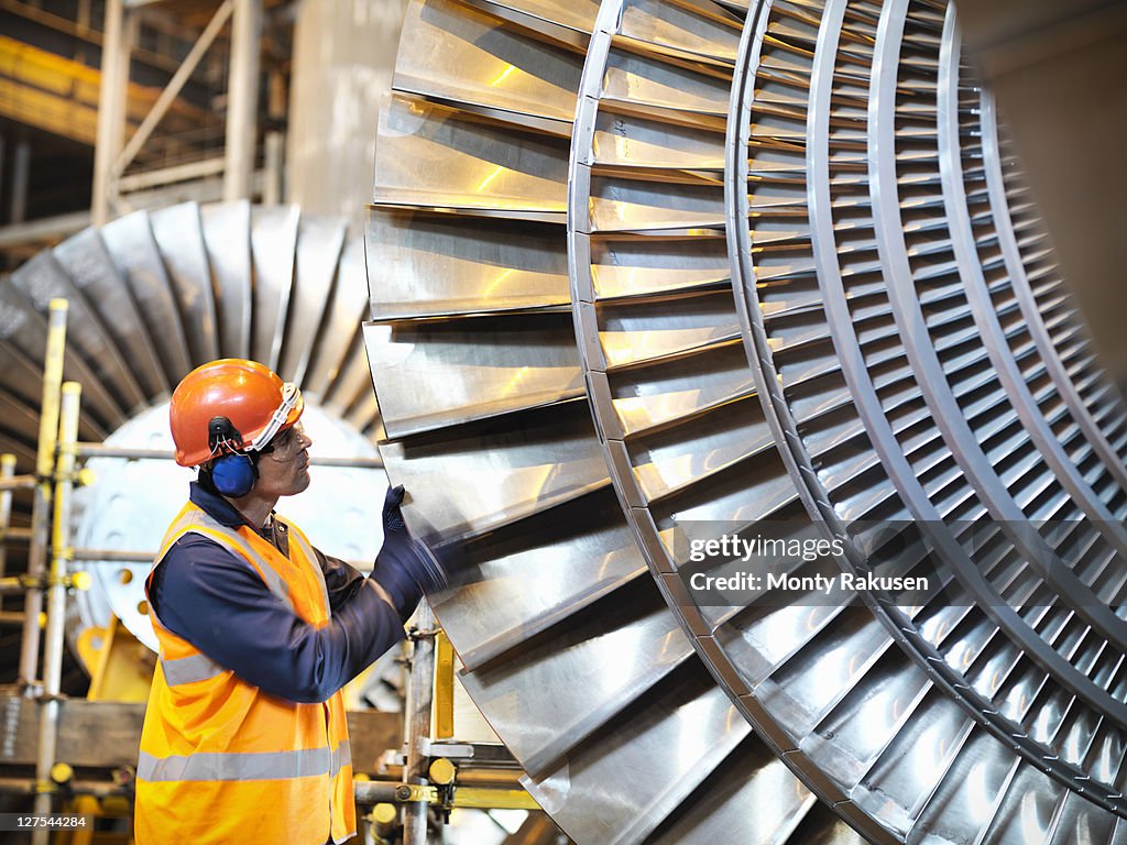 Worker inspects turbine in power station