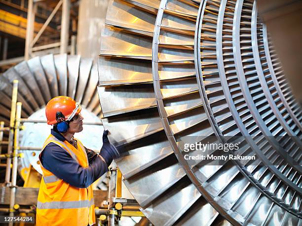 worker inspects turbine in power station - manufacturing machinery stock pictures, royalty-free photos & images