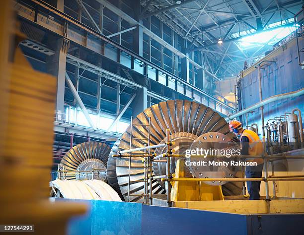 worker inspects turbine in power station - centrale elettrica foto e immagini stock