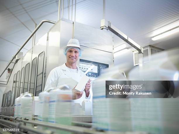 worker inspecting goat's milk in dairy - cartón de bebida fotografías e imágenes de stock