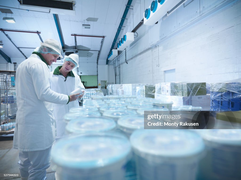 Workers with yogurt in dairy cold store