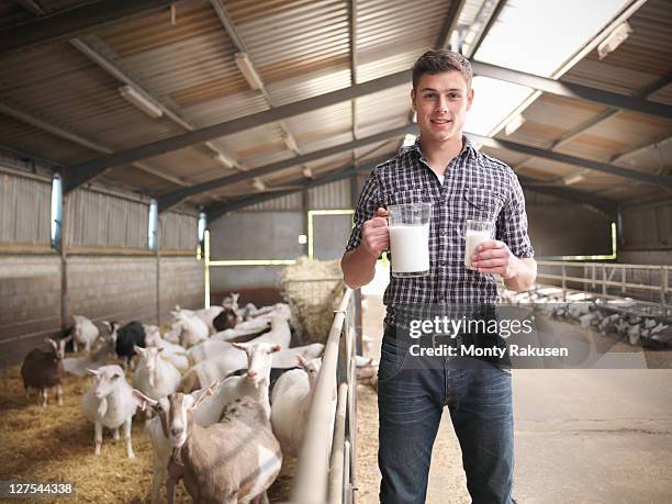 worker with glass of goatâs milk on farm - ziegenmilch stock-fotos und bilder