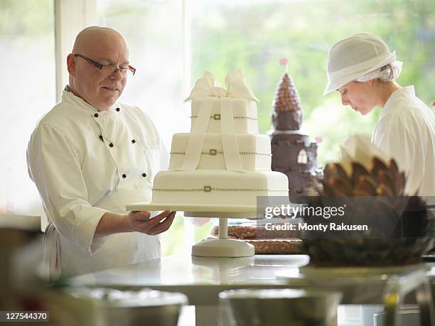 baker checking decorative wedding cake - chef patissier stock pictures, royalty-free photos & images