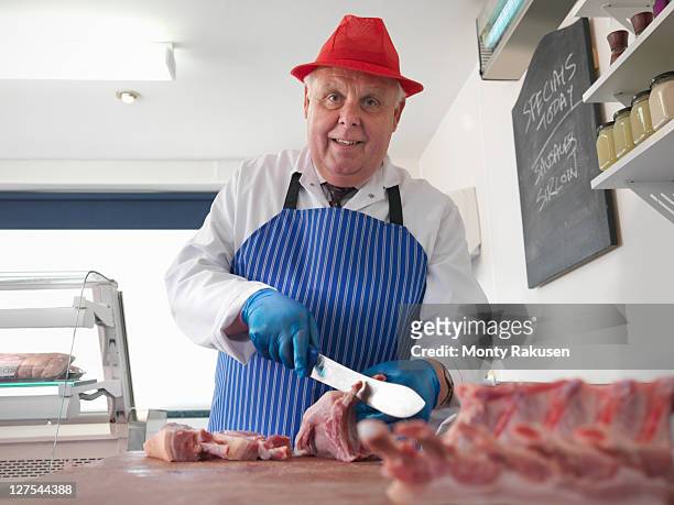 butcher carving meat in shop - butcher portrait stock pictures, royalty-free photos & images