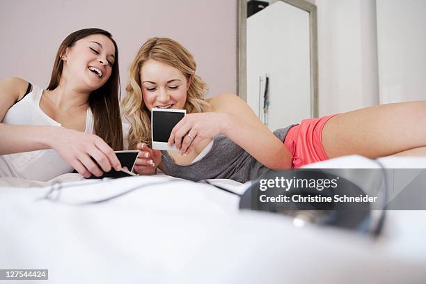 teenage girls examining polaroids - bedroom photos stock-fotos und bilder