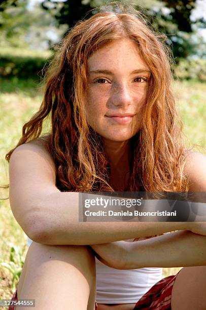 fille assise dans l'herbe dans le jardin - cheveux roux photos et images de collection