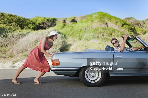 女性車を押すボーイフレンドの去勢牛 - summer press day ストックフォトと画像
