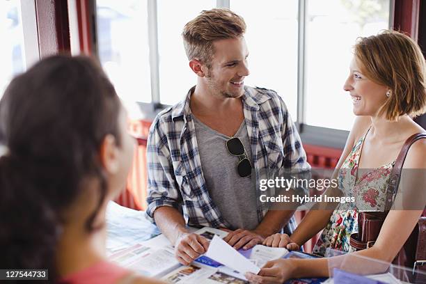 smiling couple at tourist info center - travel agent stock pictures, royalty-free photos & images