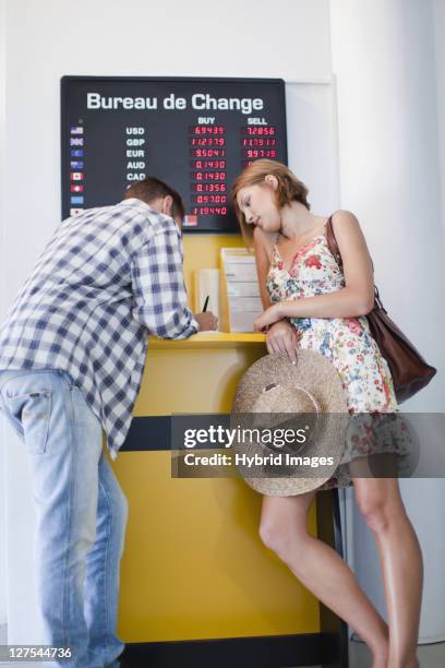 couple exchanging currency - cambio valuta foto e immagini stock