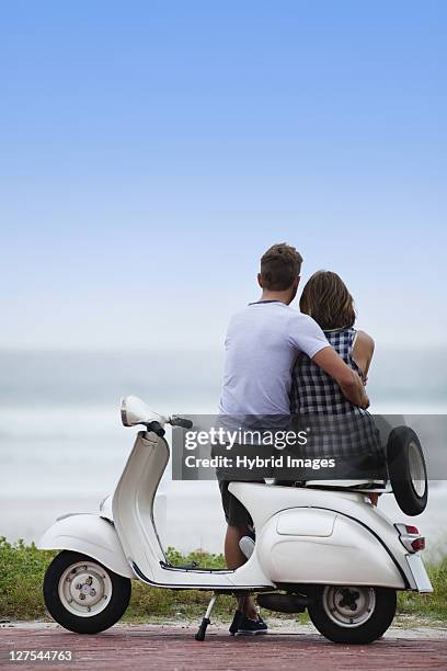 couple sitting on scooter together - hermanus stock pictures, royalty-free photos & images