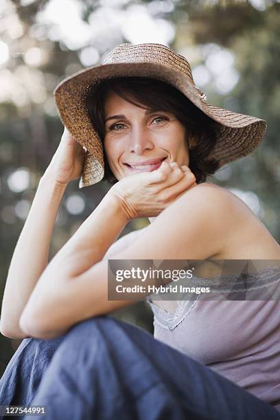 smiling woman wearing sunhat - beach hat stock pictures, royalty-free photos & images