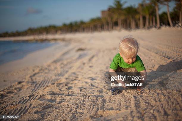 toddler boy playing with sand on beach - yucatán schiereiland stockfoto's en -beelden