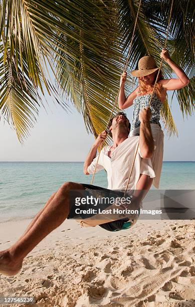 paar auf schaukel am strand - maldivas stock-fotos und bilder