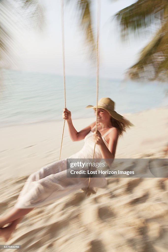 Woman swinging on tropical beach