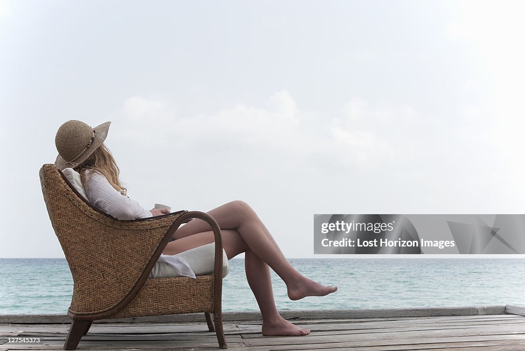 Woman relaxing with coffee on deck