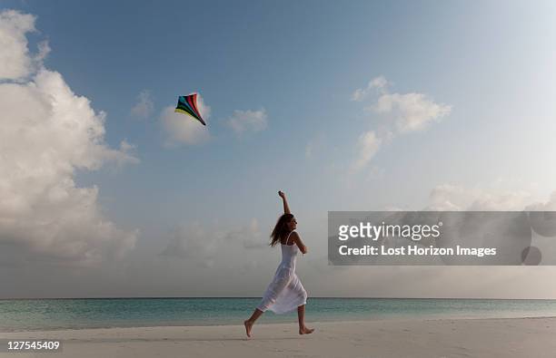 mulher com um papagaio voar na praia tropical - ir em frente imagens e fotografias de stock