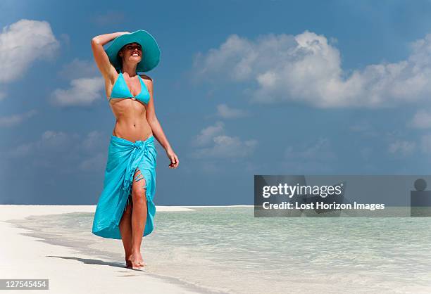 woman walking on tropical beach - sarong stock pictures, royalty-free photos & images