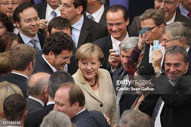 German Chancellor Angela Merkel smiles shortly after casting her ballot along with other Bundestag members in voting on an increase in funding for...