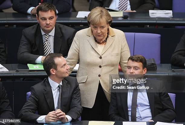German Chancellor Angela Merkel chats with members of her political party, the German Christian Demoocrats during a session of the Bundestag in which...