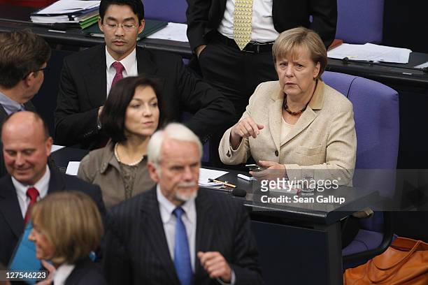 German Chancellor Angela Merkel looks on as Bundestag members cast their ballots in voting on an increase in funding for the European Financial...