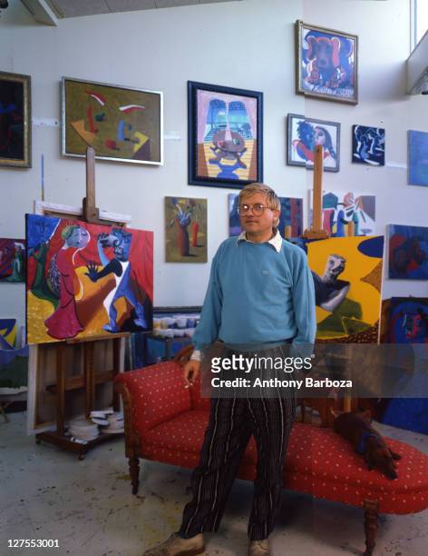 Portrait of English painter David Hockney, dressed in a light blue sweatshirt and striped trousers, Los Angeles, California, 1980s.
