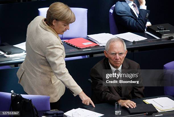 Angela Merkel, Germany's chancellor, left, gestures as she speaks with Wolfgang Schaeuble, Germany's finance minister, ahead of a vote to expanded...