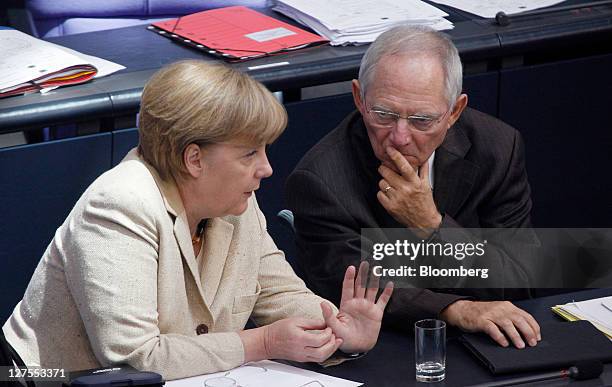 Angela Merkel, Germany's chancellor, left, gestures as she speaks with Wolfgang Schaeuble, Germany's finance minister, ahead of a vote to expanded...