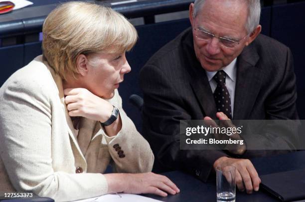 Angela Merkel, Germany's chancellor, left, speaks with Wolfgang Schaeuble, Germany's finance minister, ahead of a vote to expanded the powers of the...