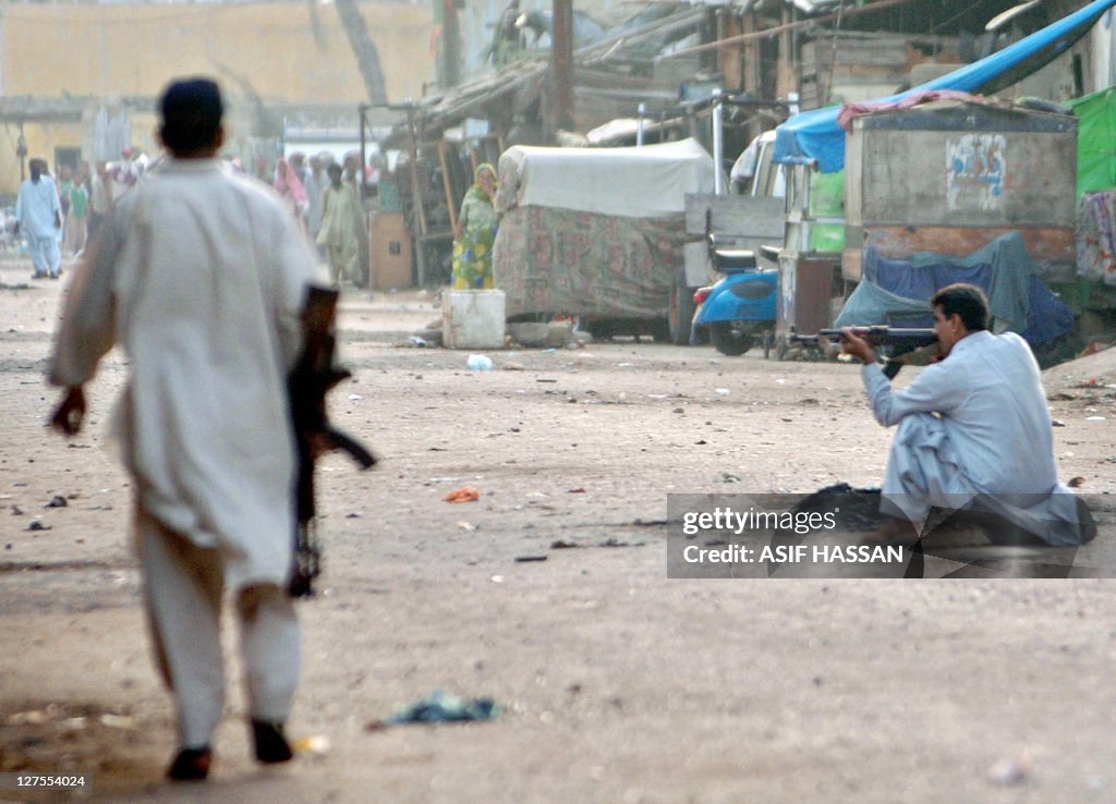 A Pakistani plain-clothes policeman (R)