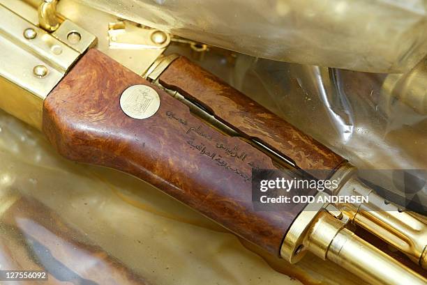 Golden Kalashnikov rifle with the Arabic inscription "A gift from Iraqi President Saddam Hussein" is seen in a plastic bag 12 April 2003, in Baghdad...