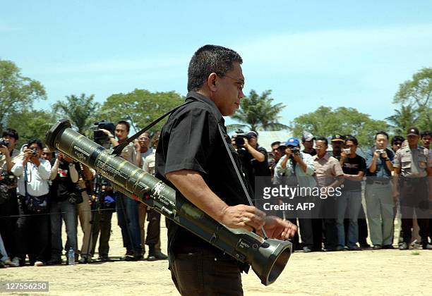 Free Aceh Movement member Iswandi Yusuf carries a bazooka during a disarmament ceremony in Banda Aceh, 15 September 2005. Separatist rebels in...