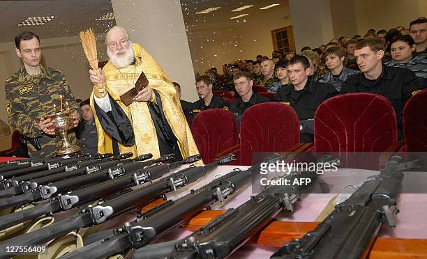 Russian Orthodox priest blesses new Kalashnikov machine guns during a ceremony presenting the new weapons to recently enlisted members of Russia's...
