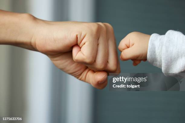 fist bump - tiny hands stock pictures, royalty-free photos & images