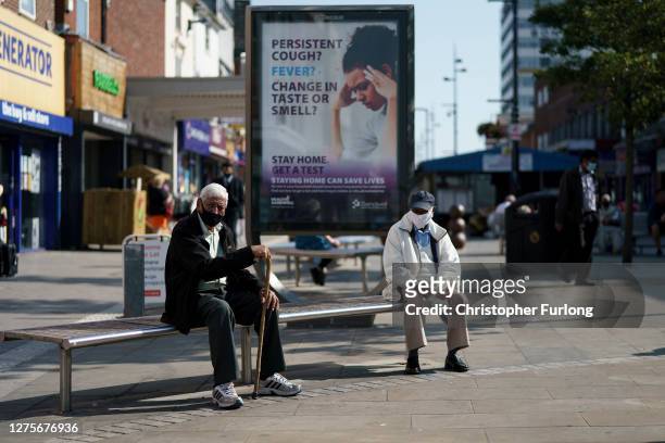 People enjoy the last fo the Summer sunshine as they wear protective face masks in the High Street on September 22, 2020 in West Bromwich, United...