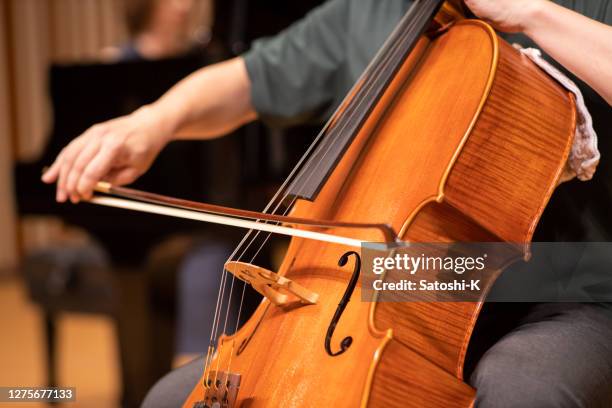 close-up van cellist die bij klassiek overleg speelt - strijkstok stockfoto's en -beelden