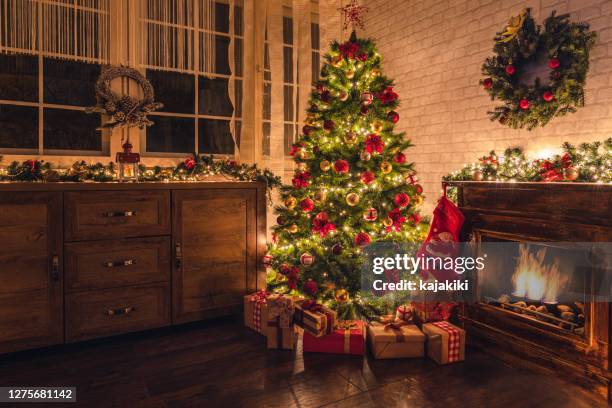 arbre de noël décoré près de la cheminée à la maison - sapin de noël photos et images de collection