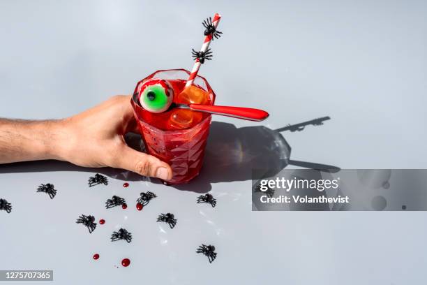 halloween eyeball in a red spoon with spiders and blood on gray background - tomato juice stock pictures, royalty-free photos & images