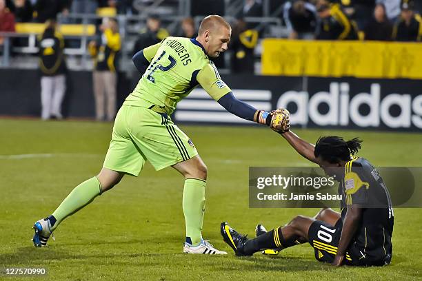 Goalkeeper Josh Saunders of the Los Angeles Galaxy gives a helping hand to Andres Mendoza of the Columbus Crew on September 24, 2011 at Crew Stadium...