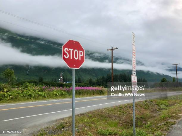 mountain clouds, stop sign and communications tower in valdez, alaska, usa - adelfilla enana fotografías e imágenes de stock