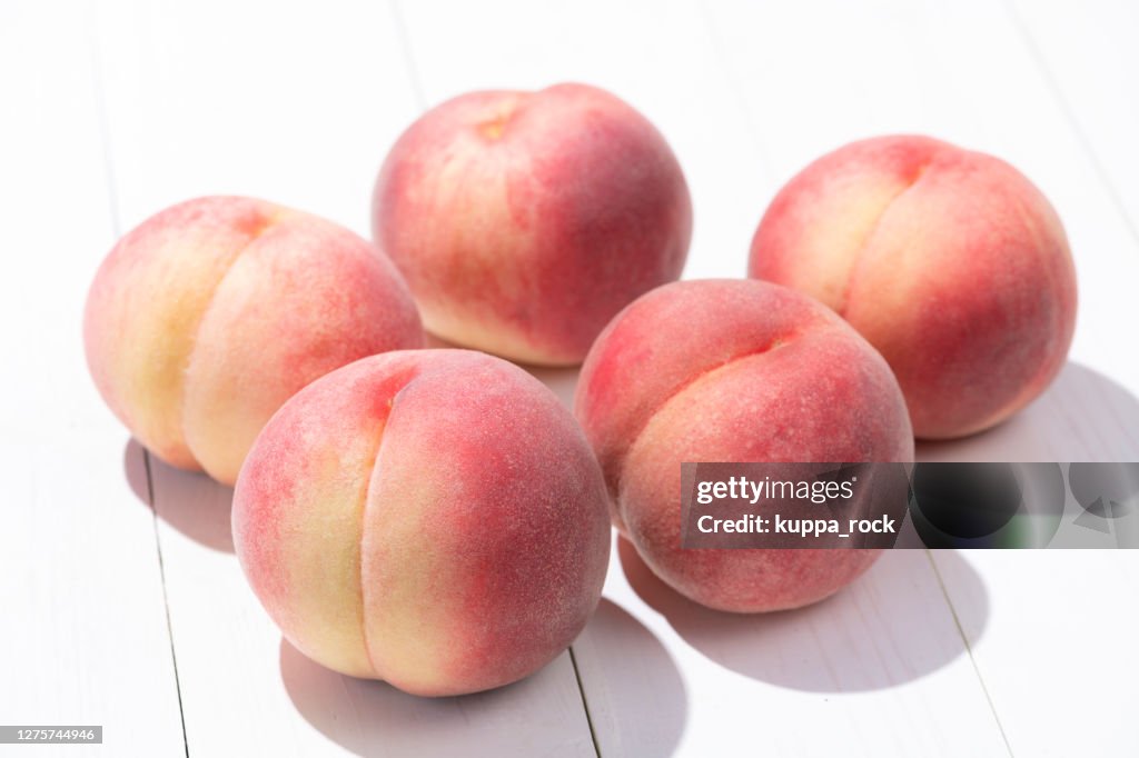 Peach on a white board. Summer fruits.