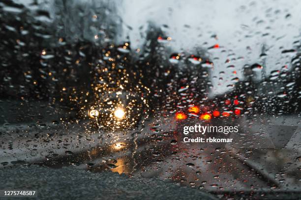 blurred drizzle on the windshield in the evening - bad weather on window stock pictures, royalty-free photos & images