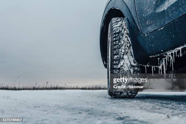 car rides on an icy road - autoreifen natur stock-fotos und bilder