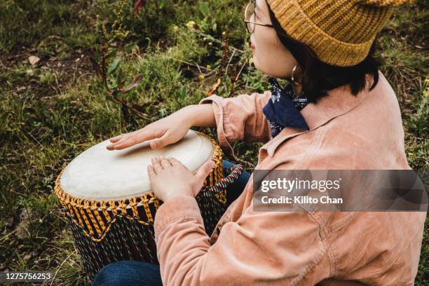 asian woman playing bongo outdoor in the wild nature - bongo foto e immagini stock