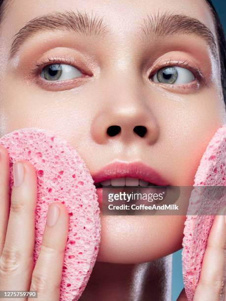 de jonge vrouw reinigt de huid natuurlijke spons - pores stockfoto's en -beelden