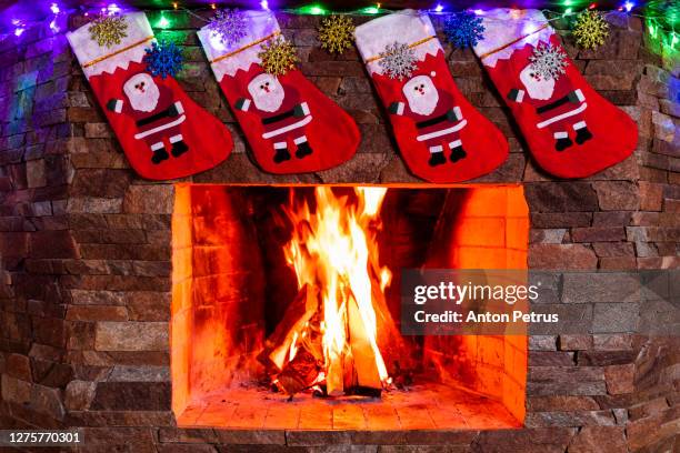 fireplace with beautiful christmas decorations - chaussette noel cheminée photos et images de collection