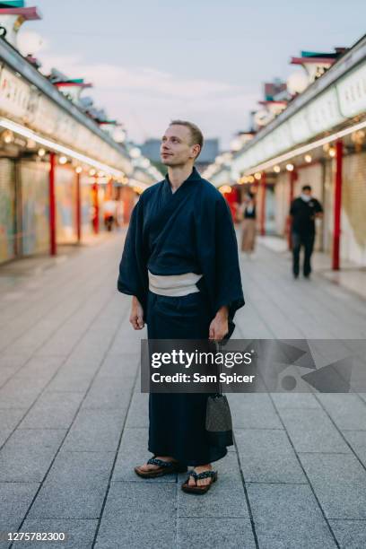 male tourist wearing traditional japanese yukata in tokyo, japan - kimono photos et images de collection
