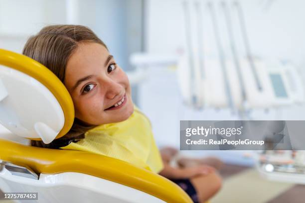 chica linda en la silla del dentista sonriendo - odontopediatría fotografías e imágenes de stock